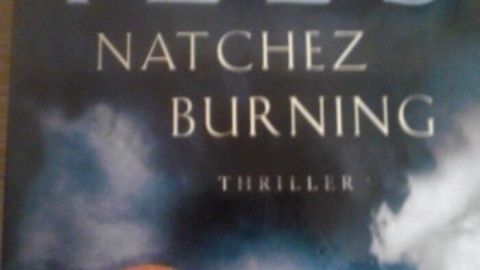 Ein Buchcover zeigt "Natchez Burning" von Greg Iles, mit düsterem Himmel und dem Hinweis auf den Bestsellerstatus.