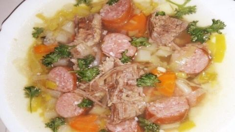 Ein herzhaftes Gemüseeintopf mit zarten Rinderbruststücken und Mettenden, garniert mit frischem Grün.