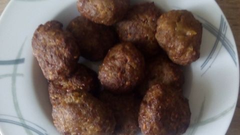Mini-Frikadellen auf einem Teller liegen appetitlich beieinander. Sie sind goldbraun und knusprig aus der Heißluftfritteuse.