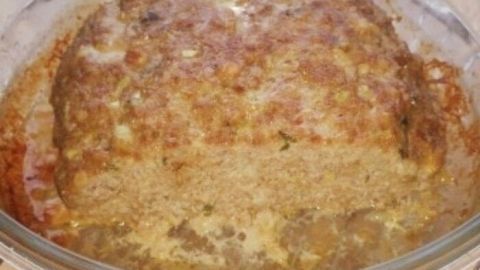 Ein goldbrauner Hackbraten steht in einer Mikrowellenschüssel und dampft leicht, bereit zum Servieren.