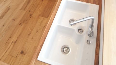 Eine moderne Küchenspüle wird mit Wasser gefüllt, um die Reinigung in einer hellen, einladenden Küche zu ermöglichen.