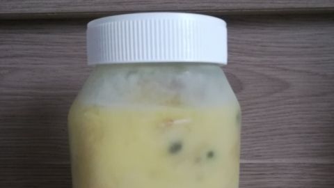Ein Glas mit gefrorenem Inhalt steht auf einer Arbeitsplatte in einer Küche. Es zeigt, wie Lebensmittel zum Einfrieren vorbereitet sind.
