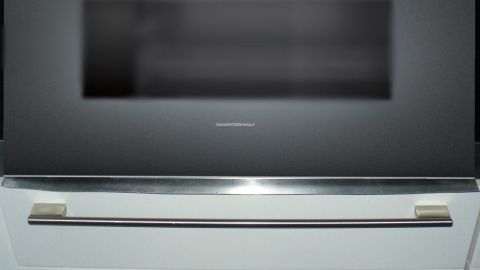 Der moderne Backofen zeigt Kondenswasser auf der Glasfront, während er in einer modernen Kücheneinrichtung steht.