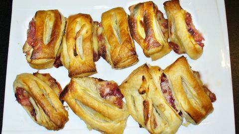 Blätterteigstrudel sind auf einem weißen Teller angerichtet, die goldbraun und frisch gebacken aussehen.