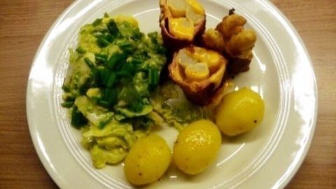 Auf einem Teller liegen Spargel-Cordon-Bleu-Stücke neben Butterkartoffeln und einem grünen Salat.