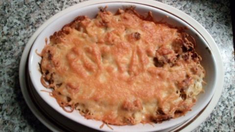 Überbackene Thunfisch-Spaghetti sind in einer gebackenem Form zu sehen, knusprig und goldbraun, auf einer marmorierten Oberfläche.