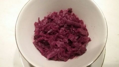 Ein tiefrotes Rote-Bete-Gemüse liegt in einer weißen Schüssel und wirkt frisch zubereitet auf einem hellen Hintergrund.