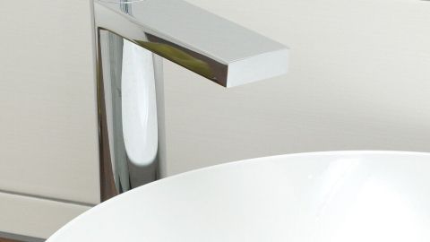 Ein modernes Waschbecken mit einer glänzenden Armatur steht auf einer Holzoberfläche, bereit zur Nutzung in einem eleganten Badezimmer.