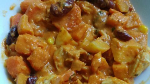 Zarte Hähnchengeschnetzeltes liegt in einer cremigen Chili-Sahne-Soße, zusammen mit buntem Gemüse in einer Schale.