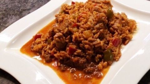 Ein Teller mit Wiener Reisfleisch zeigt saftigen Reis, zarte Fleischstücke und bunte Paprika in einer würzigen Sauce.