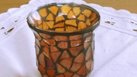 Ein dekoratives Duftschälchen aus buntem Glas steht auf einem weißen Tuch, bereit zum Befüllen mit duftenden Ölen.