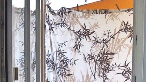 Ein nasses Tuch hängt an einem Fenster, um die Hitze in der Wohnung zu reduzieren und Schatten zu spenden.