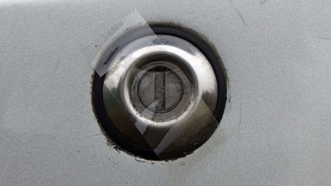 Einfacher und preiswerter Tipp gegen das Einfrieren von Autotürschlössern. Ein Autotürschloss ist im Fokus, umgeben von einer grauen Karosserie; der Schlüsselbereich zeigt Spuren von Frostschutzmaßnahmen.