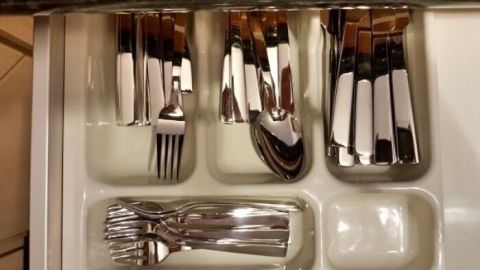 Sauberes Besteck ist ordentlich in einer Schublade angeordnet. Gabeln, Messer und Löffel sind getrennt in Fächern.