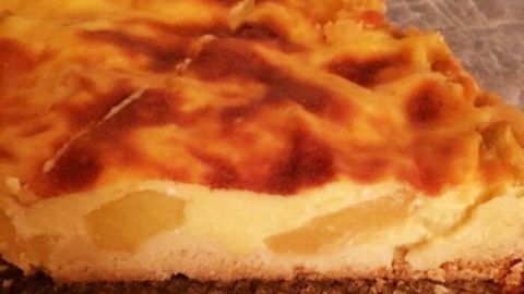 Ein goldbraun gebackener Apfelkuchen mit Guss liegt auf einem Kuchengitter und verströmt einen köstlichen Duft.