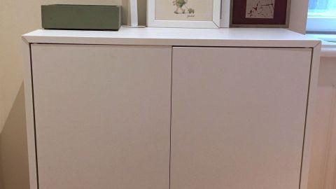 Eine versteckte Katzentoilette in einem modernen, weißen Schrank, der stilvoll im Wohnraum steht und Platz bietet.