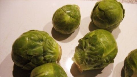 Grüne Rosenkohl-Knospen liegen auf einer Oberfläche und zeigen ihre frische, gesunde Form ideal für Wintergemüse.