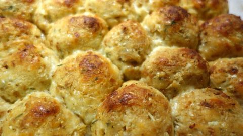 Geröstete Blumenkohl-Bällchen liegen dicht nebeneinander auf einem weißen Teller, goldbraun und knusprig gebacken.