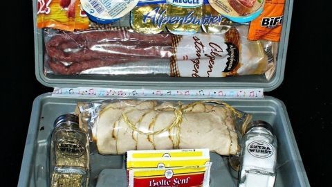 Ein Wurstkoffer enthält verschiedene Wurstsorten und Snacks, die appetitlich angeordnet sind, ideal als Männergeschenk.