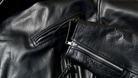 Schwarze Lederjacke mit Zippern liegt zusammengefaltet, um den üblen Geruch nach Leder und Gerbmittel zu beseitigen.