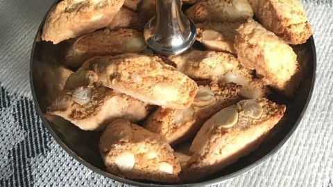 Auf einem eleganten Silbertablett liegen frisch gebackene Cantuccini, italienisches Mandelgebäck, dekorativ angeordnet.
