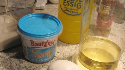 Eier und Zutaten stehen auf einer Küchearbeitsplatte, bereit zur Zubereitung von selbst gemachter Mayonnaise.