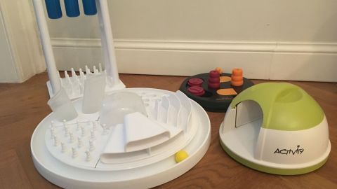 Ein interaktives Katzenspielzeug steht auf dem Boden, während die Katze aktiv damit spielt, um ihre Beschäftigung zu fördern.