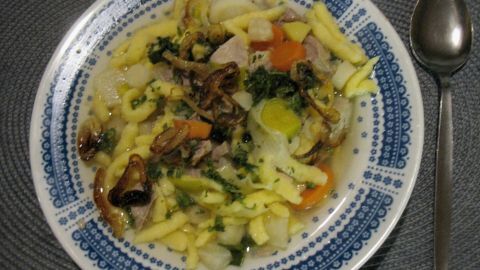 Ein herzhaftes Gericht aus einem bunten Gemüsetopf mit Schweinefleisch und Spätzle in einer dekorativen Schüssel.