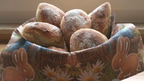 In einer dekorativen Schale liegen frisch gebackene Joghurtbrötchen, umgeben von einem hellen Küchenambiente.