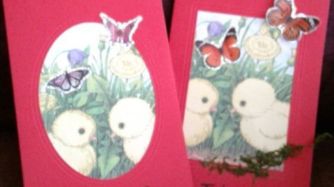 Zwei liebevoll gestaltete Osterkarten liegen auf einem Tisch, geschmückt mit bunten Schmetterlingen und dem Text „Frohe Ostern“.