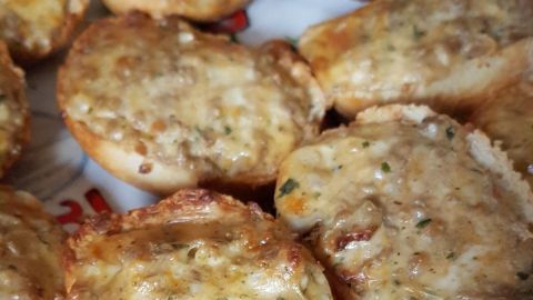 Überbackene Brötchen mit Rinderhack und Emmentaler liegen appetitlich auf einem Teller und zeigen eine goldbraune, knusprige Oberfläche.