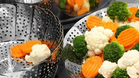 Bunte Gemüsesorten wie Karotten, Brokkoli und Blumenkohl werden in einem Dampfgarer zubereitet, um Vitaminverlust zu vermeiden.