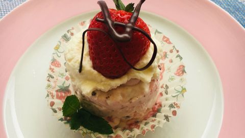 Ein schwedisches Eistörtchen wird serviert, dekoriert mit Erdbeeren und Schokolade, auf einem geschmackvollen Teller.
