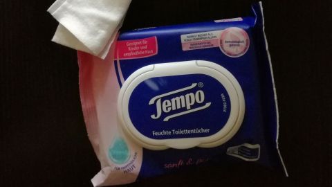 Reinigungstücher liegen auf einem Tisch. Eine Packung Dettol und eine von Tempo sind sichtbar und gut verpackt.
