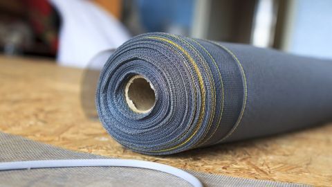 Ein Fliegennetz-Rollenmaterial liegt auf einem Tisch, bereit zum Öffnen und Schließen für eine Insektenabwehr.
