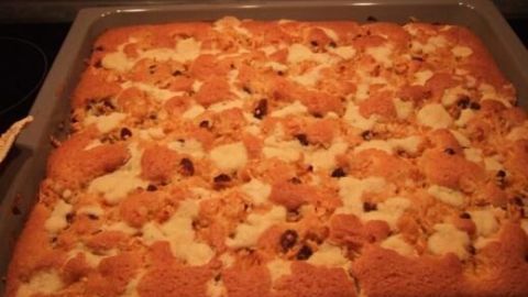 Ein frisch gebackener Apfel-Streuselkuchen liegt in einer Form und zeigt goldbraune Streusel über einer weichen, fruchtigen Füllung.