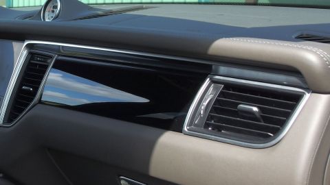 Eine elegante Auto-Armatur wird mit Baby-Feuchttüchern gereinigt, um Schmutz zu entfernen und Glanz zu verleihen.