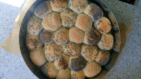 Eine Platte mit frisch gebackenen Partybrötchen liegt auf einem Tisch, bereit für eine festliche Veranstaltung.
