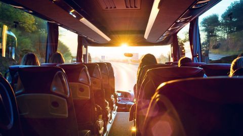 Bequeme Sitze im Bus bieten Passagieren eine entspannte Fahrt, während die Sonne durch die Windschutzscheibe scheint.