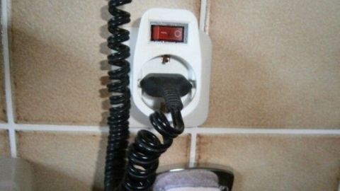 Eine steckbare Zeitschaltuhr zeigt die verbleibende Zeit an, während sie an einer Wandsteckdose im Badezimmer steckt.