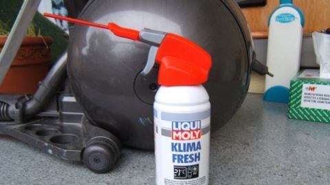 Ein Sprayflasche steht auf einer Arbeitsfläche neben einem Dyson Staubsauger, um Gerüche zu beseitigen.