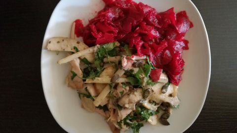 Ein Teller zeigt Kräuterseitlinge mit frischen Kräutern, neben einem leuchtend roten Salat aus Rote Rüben.