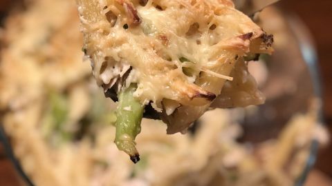 Ein Löffel Brokkoli-Thunfisch-Auflauf wird gerade aus einer Glasschüssel gehoben, um eine köstliche Portion zu servieren.
