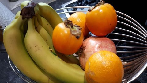 Bananen und verschiedene Früchte liegen in einer Schüssel, um Fruchtfliegen zu vermeiden und Frische zu behalten.
