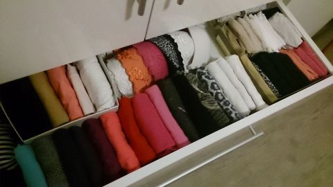 In einem aufgeräumten Schublade liegen ordentlich gefaltete Kleidungstücke in verschiedenen Farben, die für Ordnung im Schrank sorgen.