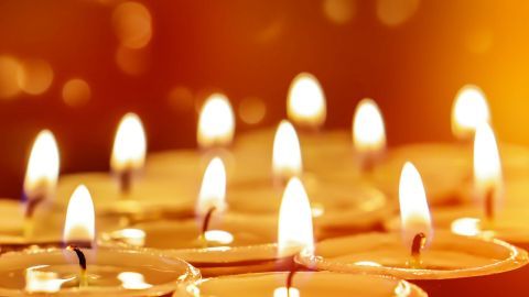 Teelichter flammen in einem warmen Licht, umgeben von einem sanften, goldenen Hintergrund, der Gemütlichkeit vermittelt.