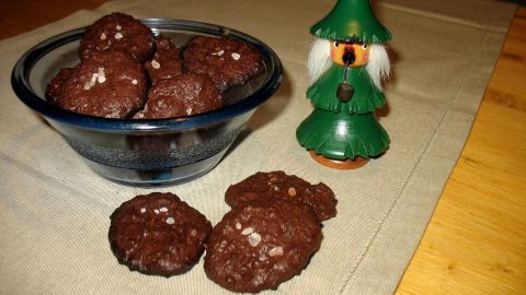 Eine Schüssel mit Schoko-Vollkorn-Cookies steht auf einem Tisch, daneben steht eine kleine Dekorationsfigur im grünen Hut.