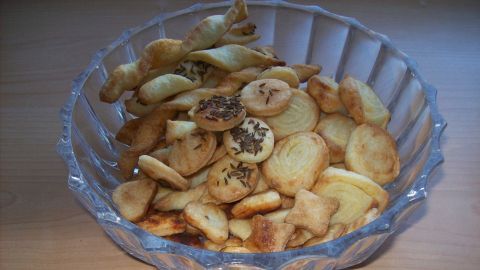 Eine Schüssel voller herzhafter Knabbereien liegt auf einem Tisch, die Knabbereien sind knusprig und appetitlich angerichtet.