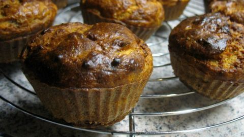 Süßkartoffel-Bananen-Muffins sind gleichmäßig goldbraun und stehen auf einem Kuchengitter in einer Küchenumgebung.