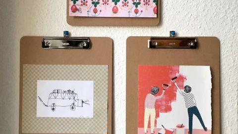 Klemmbretter halten kreativ gestaltete Bilder an einer Wand, um eine persönliche und ansprechende Dekoration zu schaffen.